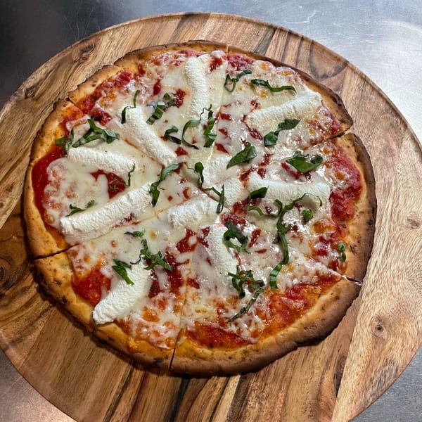 Sonia's Gourmet Kitchen's Italian pizza, topped with tomato sauce, mozzarella, ricotta, and fresh basil.