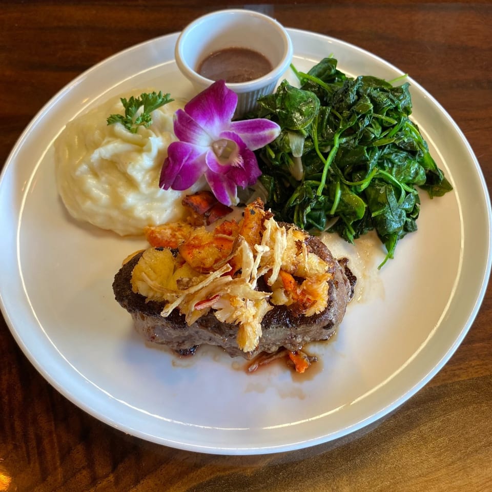 Steak topped with lobster and crispy onions, served with mashed potatoes, spinach, and gravy.