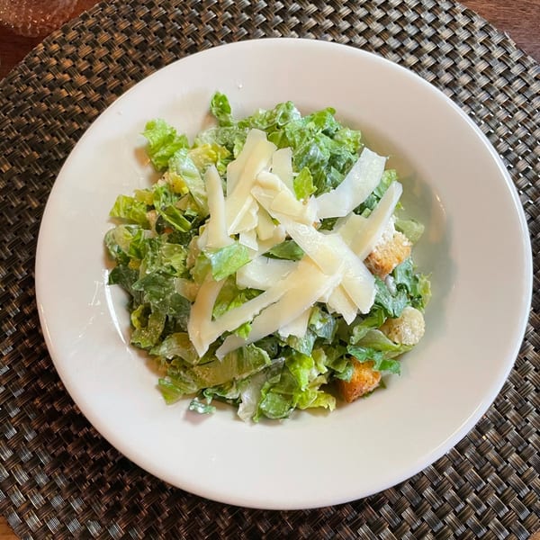 A fresh Caesar salad from Sonia's Gourmet Kitchen, topped with shaved Parmesan and croutons.